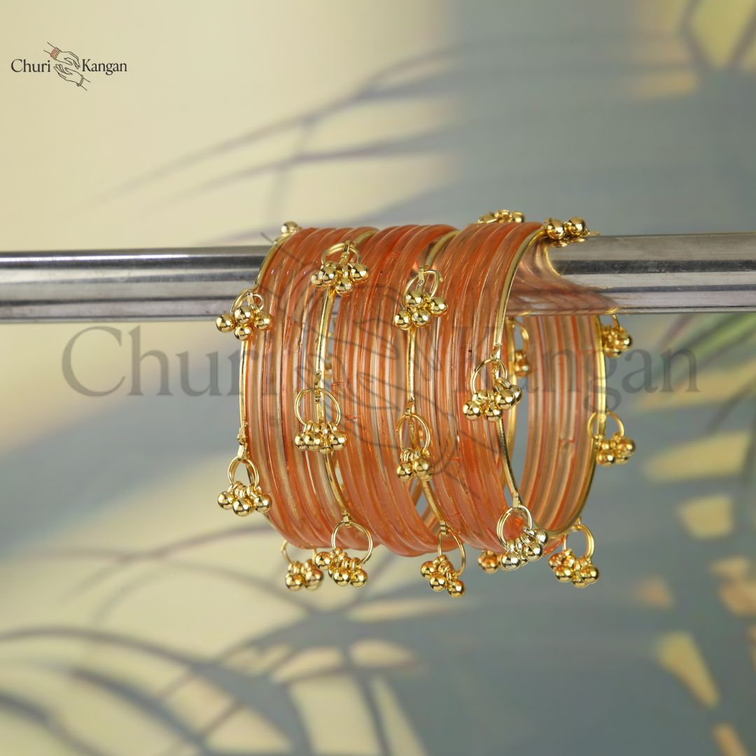 Peach glossy jelly kangan bangles with golden accents